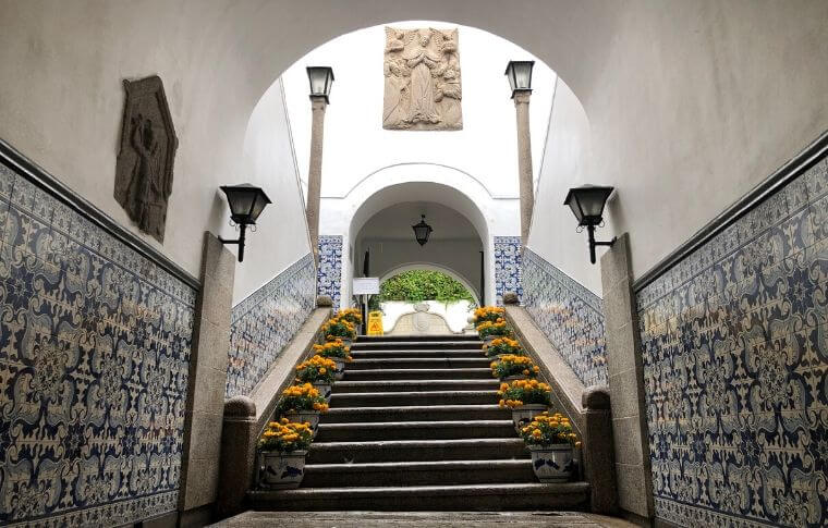 stairs leading to opening with tiles and flowers on either side